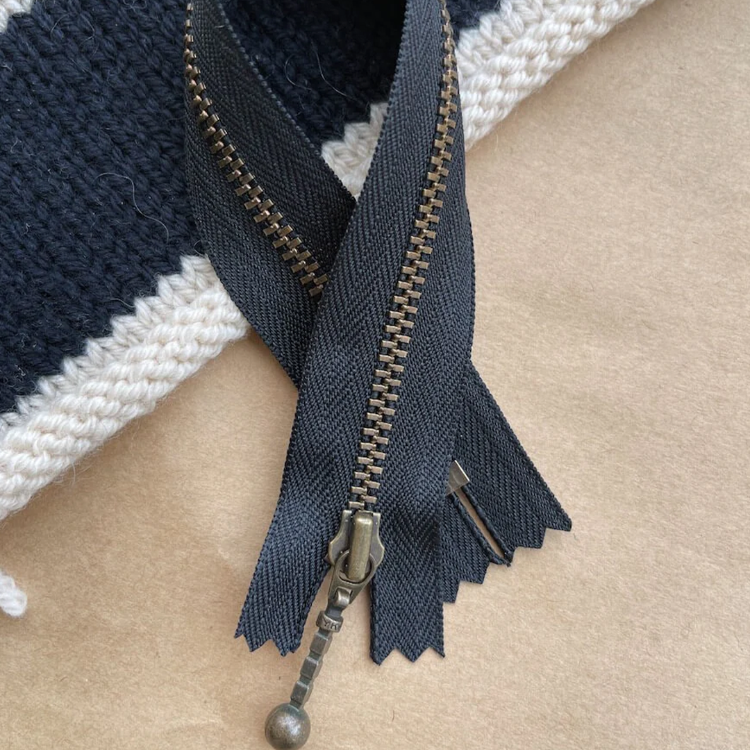 Lynlås fra Petiteknit med en længde på 23 cm. Vælg mellem farverne: Citronfromage, Chokoladebrun, Havskum, Hasselnød, Isblå, Flint, Navy, Perlemor, Pudderrosa, Sand og Sort. Passer til stor Honey Purse, stor Technicolor Purse, Honey Washbag, stor Marie Clutch, stor Marie Purse og lille Florence Bag. Mål: Længde: 23 cm, bredde: 4 mm